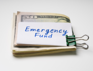 Bundled cash is held together with a binder clip with a note identifying this money as someone’s emergency fund.